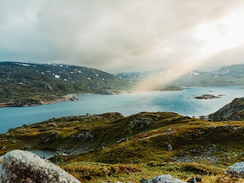 Solen bryter fram över en fjord på ett högt fjällplatå