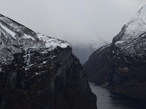 Snötäckta klippor som faller ner i en smal fjord